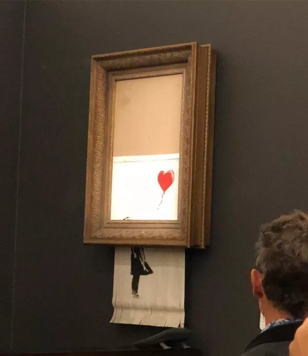Работа художника Бэнкси Девочка с шаром во время самоуничтожения на аукционе Sotheby's в Лондоне