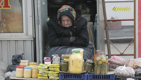 Пожилая женщина торгует на улице в Киеве. Архивное фото Пожилая женщина торгует на улице в Киеве. Архивное фото