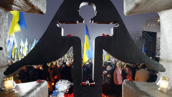 Люди зажигают свечи в день памяти жертв голодомора 1932-1933 годов на Украине 