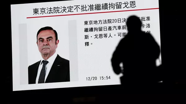Новости о бывшем главе концерна Nissan Карлосе Гоне на телеэкране в Токио, Япония