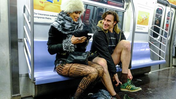 Участники флешмоба В метро без штанов в вагоне поезда метро Нью-Йорка