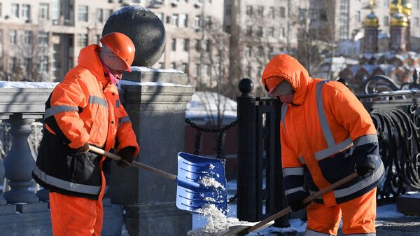 Сотрудники коммунальных служб убирают снег Сотрудники коммунальных служб убирают снег