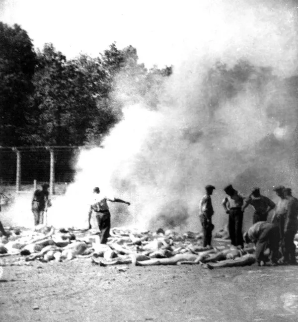 Члены зондеркоманды сжигают тела убитых газом заключенных Освенцима