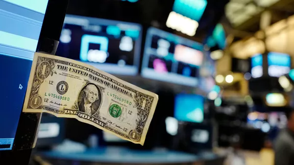 Долларовая банкнота прикреплена к экрану компьютера трейдера на Нью-Йоркской фондовой бирже