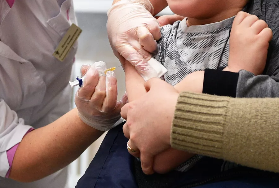 Медицинская сестра делает укол ребенку в детской поликлинике