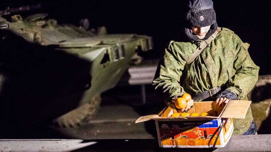 Военнослужащий с ящиком мандаринов на блокпосту на въезде в Крым в районе Армянска Военнослужащий с ящиком мандаринов на блокпосту на въезде в Крым в районе Армянска