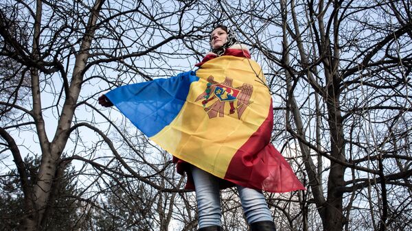Участница акции протеста оппозиции в Кишиневе в национальном флаге Молдовы Участница акции протеста оппозиции в Кишиневе в национальном флаге Молдовы