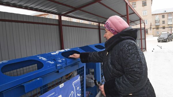 Женщина выбрасывает мусор в баки для раздельного сбора отходов в Московской области Женщина выбрасывает мусор в баки для раздельного сбора отходов в Московской области