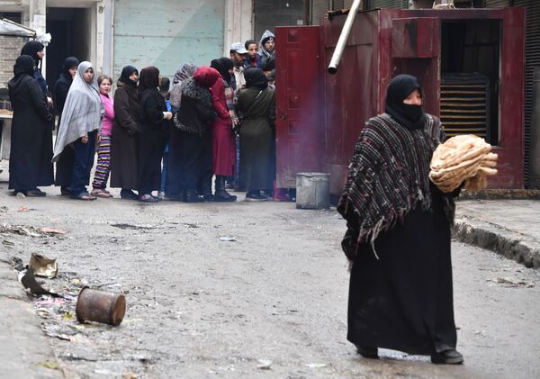 Местные жители в очереди за хлебом на одной из улиц в Алеппо