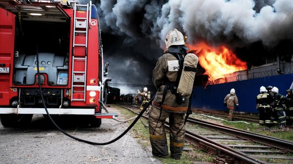 Сотрудники МЧС во время тушения пожара на складе с полиэтиленовой и бумажной тарой в промышленной зоне Краснодара. 12 марта 2019 