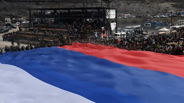 Участники автопробега мотоклуба Ночные волки в Крыму растягивают гигантский флаг России на горе Гасфорта в Севастополе. 16 марта 2019