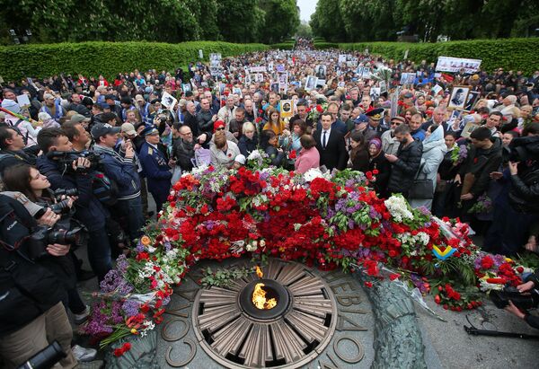 Участники акции Бессмертный полк возлагают цветы к Вечному огню в киевском парке Славы Участники акции Бессмертный полк возлагают цветы к Вечному огню в киевском парке Славы
