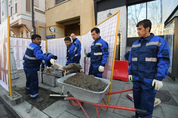 Рабочие укладывают тротуарную плитку на Никитском бульваре в Москве Рабочие укладывают тротуарную плитку на Никитском бульваре в Москве
