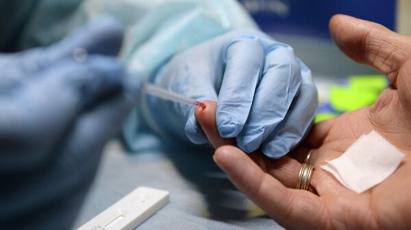 Медицинский работник производит экспресс-анализ крови на ВИЧ