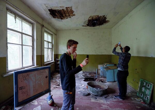 Туристы фотографируются в детском саду в заброшенном поселке Копачи, недалеко от Чернобыльской АЭС, Украина Туристы фотографируются в детском саду в заброшенном поселке Копачи, недалеко от Чернобыльской АЭС, Украина