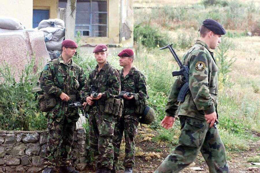 Солдат югославской армии проходит мимо солдат 1-й воздушно-десантной дивизии Великобритании по дороге к аэропорту Приштины Солдат югославской армии проходит мимо солдат 1-й воздушно-десантной дивизии Великобритании по дороге к аэропорту Приштины