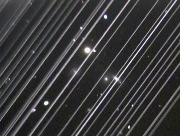 Фотография группы галактик NGC 5353/4 в созвездии Гончих Псов. Светлые линии на снимке – спутники системы Starlink Фотография группы галактик NGC 5353/4 в созвездии Гончих Псов. Светлые линии на снимке – спутники системы Starlink