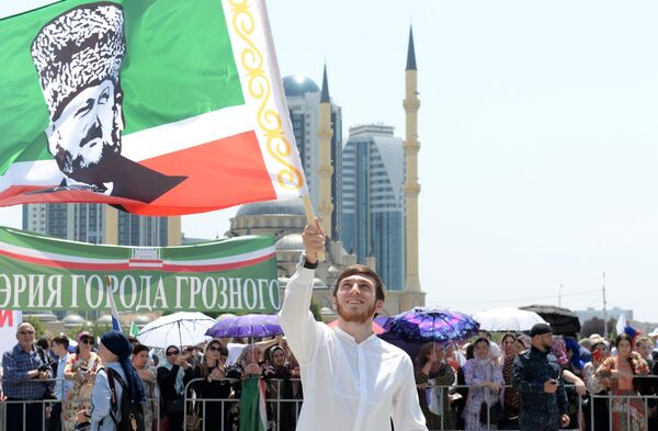 Участник праздничного митинга, посвященного Дню России, на площади перед мечетью Сердце Чечни в Грозном Участник праздничного митинга, посвященного Дню России, на площади перед мечетью Сердце Чечни в Грозном