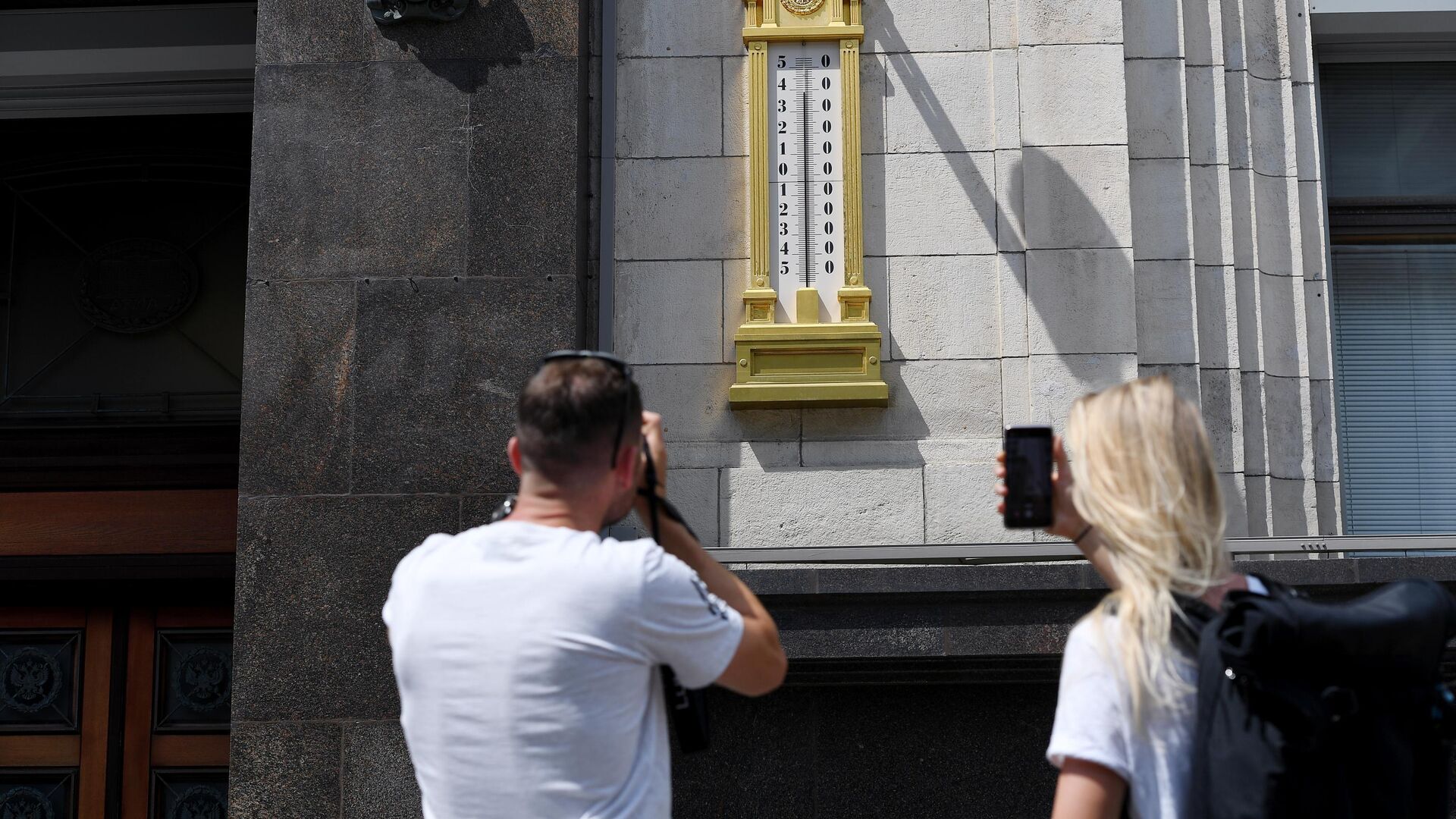 Молодые люди фотографируют термометр на здании Государственной Думы РФ в Москве Молодые люди фотографируют термометр на здании Государственной Думы РФ в Москве - РИА Новости, 1920, 13.04.2021