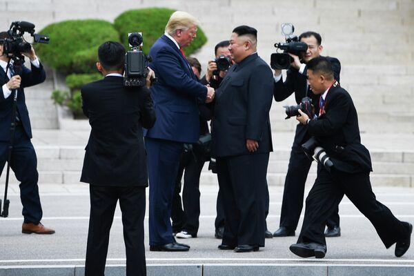Лидер Северной Кореи Ким Чен Ын пожимает руку президенту США Дональду Трампу к северу от военной демаркационной линии, разделяющей Северную и Южную Корею в Демилитаризованной зоне. 30 июня 2019 Лидер Северной Кореи Ким Чен Ын пожимает руку президенту США Дональду Трампу к северу от военной демаркационной линии, разделяющей Северную и Южную Корею в Демилитаризованной зоне. 30 июня 2019