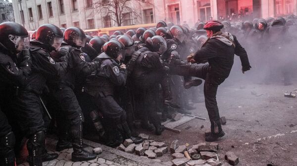 Участник акции сторонников евроинтеграции Украины перед строем сотрудников правоохранительных органов во время беспорядков возле здания Администрации президента Украины на Банковой улице в Киеве Участник акции сторонников евроинтеграции Украины перед строем сотрудников правоохранительных органов во время беспорядков возле здания Администрации президента Украины на Банковой улице в Киеве