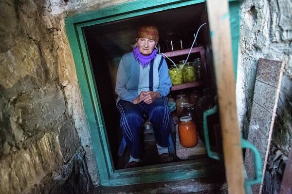 Жительница поселка Семеновка в погребе, в котором она пережидает артиллерийские обстрелы Жительница поселка Семеновка в погребе, в котором она пережидает артиллерийские обстрелы