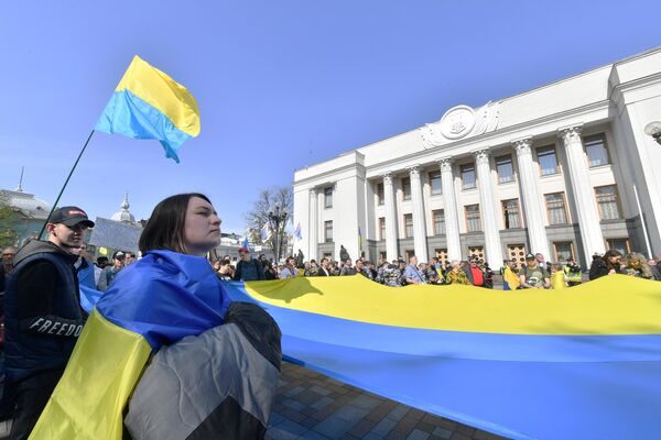 Люди c украинским флагом перед украинским парламентом в Киеве Люди c украинским флагом перед украинским парламентом в Киеве