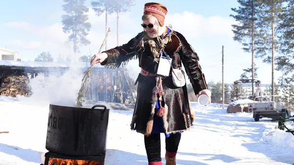 Практикующий нойд (шаман) и хранитель традиционных знаний народа саами Надя Фенина варит уху на празднике Мистический север. Праздник весеннего равноденствия