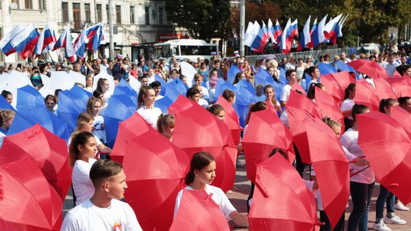 Участники мероприятий составили из зонтов российский триколор в рамках празднования Дня государственного флага Российской Федерации в центре Симферополя Участники мероприятий составили из зонтов российский триколор в рамках празднования Дня государственного флага Российской Федерации в центре Симферополя