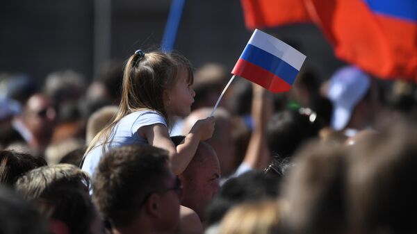 Участники флешмоба в честь Дня государственного флага России на проспекте Сахарова в Москве Участники флешмоба в честь Дня государственного флага России на проспекте Сахарова в Москве