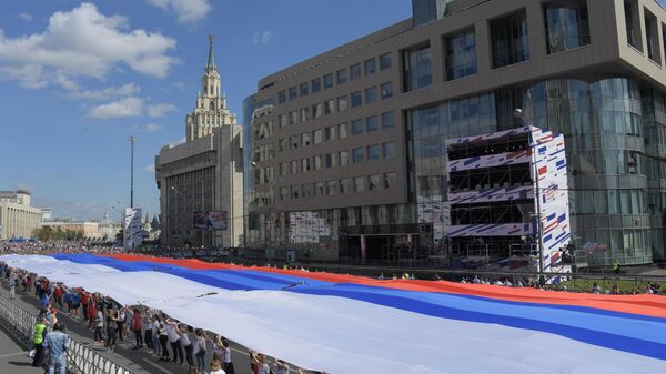 Участники флешмоба в честь Дня государственного флага России на проспекте Сахарова в Москве Участники флешмоба в честь Дня государственного флага России на проспекте Сахарова в Москве