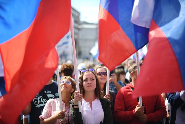 Участники флешмоба в честь Дня государственного флага России на проспекте Сахарова в Москве Участники флешмоба в честь Дня государственного флага России на проспекте Сахарова в Москве