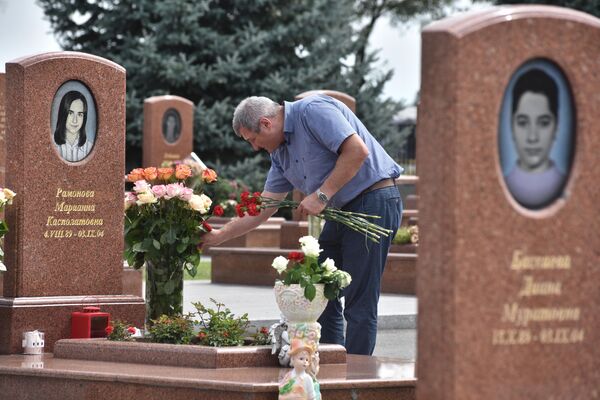 Мужчина принес цветы на могилу на мемориальном кладбище Город ангелов в Беслане, где похоронены погибшие во время теракта в 1-й Бесланской школе 1-3 сентября 2004 года Мужчина принес цветы на могилу на мемориальном кладбище Город ангелов в Беслане, где похоронены погибшие во время теракта в 1-й Бесланской школе 1-3 сентября 2004 года