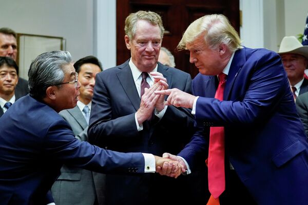 Президент США Дональд Трамп пожимает руку послу Японии в США Шинсукэ Сугияме Президент США Дональд Трамп пожимает руку послу Японии в США Шинсукэ Сугияме