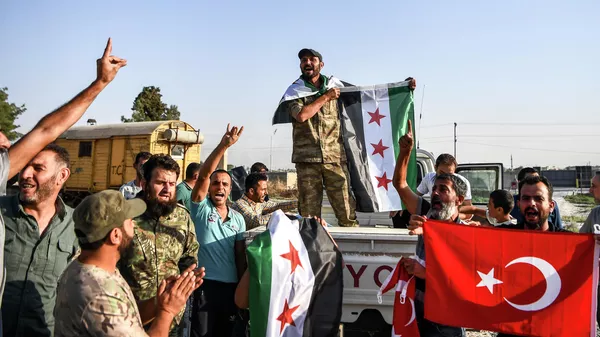 Бойцы поддерживаемой Турцией сирийской вооруженной оппозиции празднуют взятие города Телль-Абъяд.