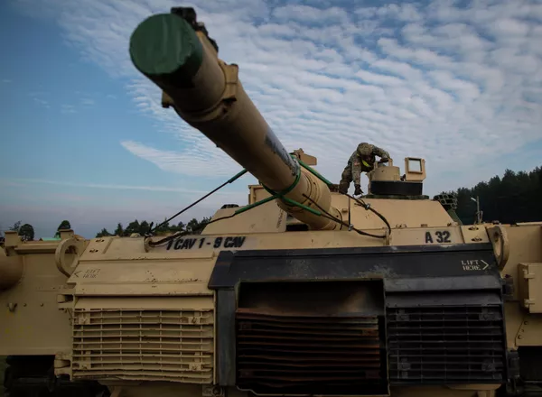 Американский военнослужащий готовит танк Abrams к разгрузке на железнодорожной станции в Литве Американский военнослужащий готовит танк Abrams к разгрузке на железнодорожной станции в Литве