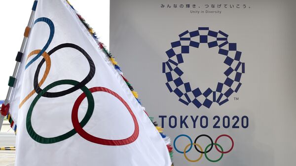 Олимпийский флаг (слева) и логотип Олимпиады-2020 в Токио
