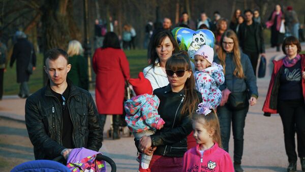 Молодая семья с детьми во время прогулки в парке Молодая семья с детьми во время прогулки в парке