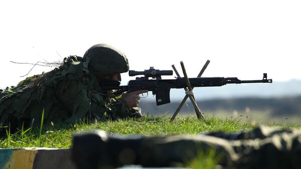 Военнослужащий стреляет из снайперской винтовки Драгунова Военнослужащий стреляет из снайперской винтовки Драгунова
