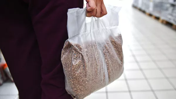 Покупательница несет пакет с гречневой крупой в одном из магазинов Симферополя