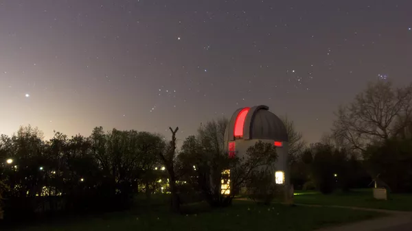 Обсерватория Йоханнеса Кеплера в Линце, Австрия, в ясную ночь. В небе видна яркая звезда Сириус, созвездие Орион, а также звездные скопления Гиад и Плеяд