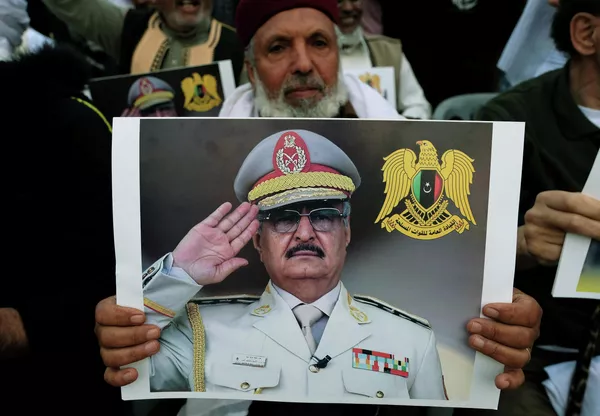 Мужчина держит фото Халифы Хафтара во время демонстрации в Бенгази