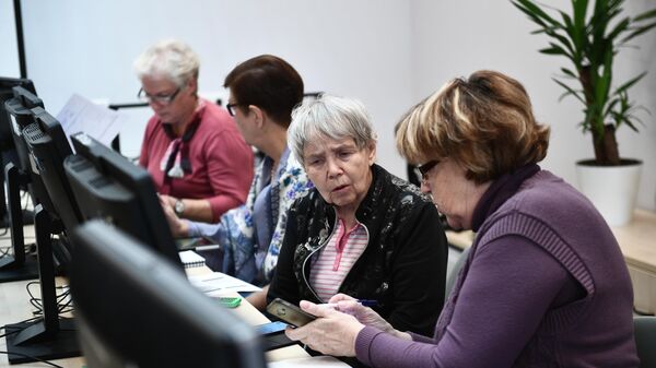 Пенсионеры во время обучения работы на компьютере Пенсионеры во время обучения работы на компьютере