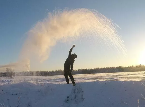 Игорь Ермаков разливает горячую воду на морозе