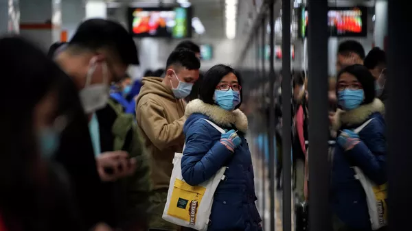 Люди в защитных масках в метро в Шанхае