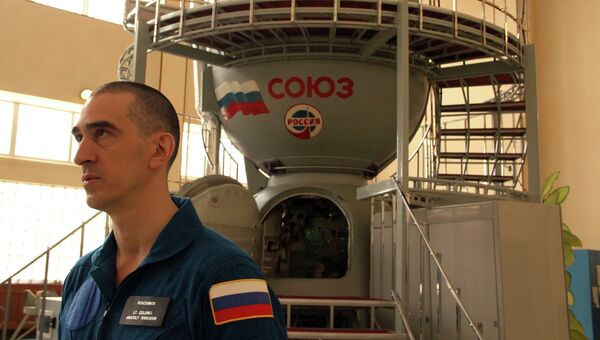 Космонавт Анатолий Иванишин на фоне тренажера корабля Космонавт Анатолий Иванишин на фоне тренажера корабля