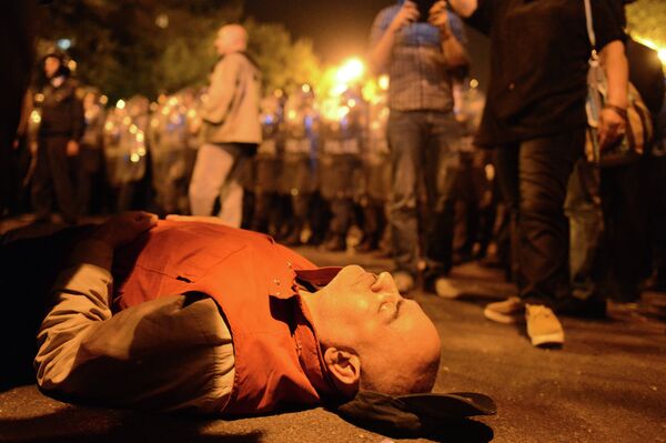 Участник шествия лежит на асфальте в знак протеста против результатов президентских выборов Участник шествия лежит на асфальте в знак протеста против результатов президентских выборов