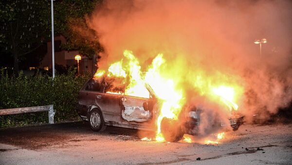 Автомобиль, сожженный в результате беспорядков в Стокгольме Автомобиль, сожженный в результате беспорядков в Стокгольме