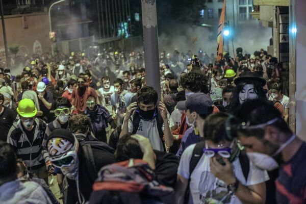Протестующие во время столкновения с сотрудниками полиции в Стамбуле Протестующие во время столкновения с сотрудниками полиции в Стамбуле