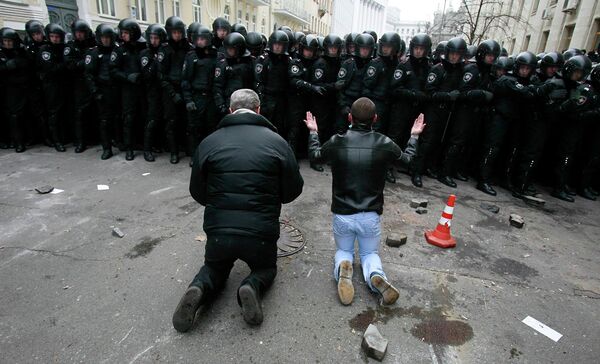 Люди стоят на коленях перед милицией во время митинга сторонников евроинтеграции в Киеве Люди стоят на коленях перед милицией во время митинга сторонников евроинтеграции в Киеве